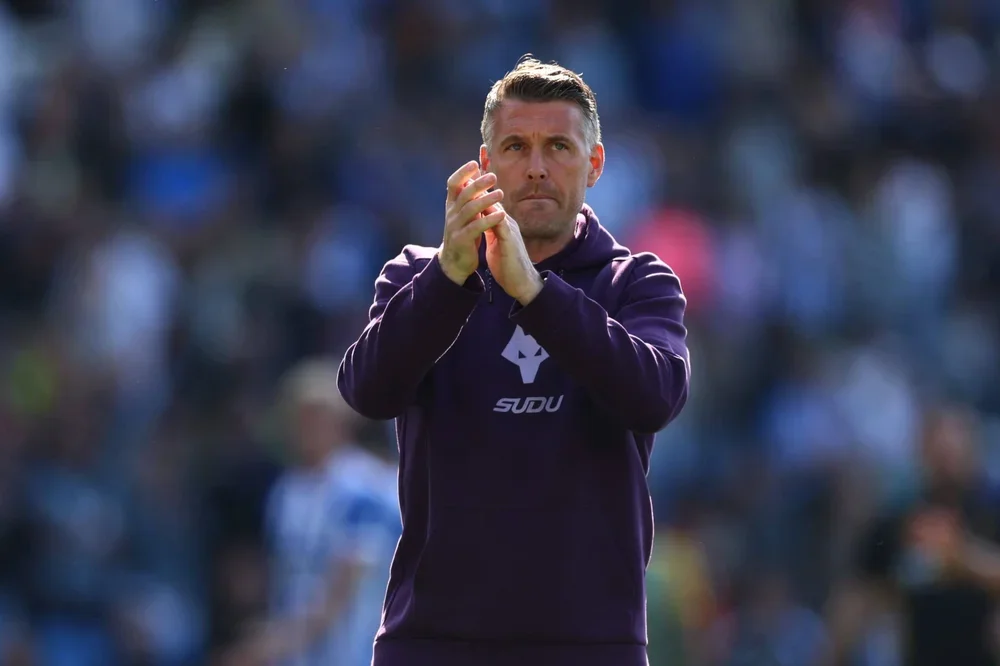 A grim-faced Rob Edwards applauds the travelling Wolves fans after Saturday's drubbing at Brighton